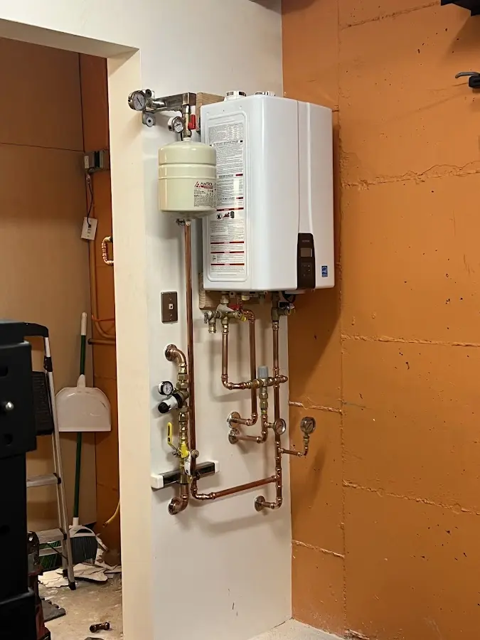 Plumbing technician inspecting water heater connections in Goleta